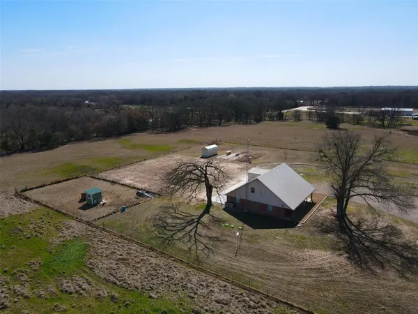 an aerial view of a house with a yard and lake view