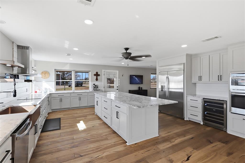 397 Rs County Road 4452 Point, TX 75472 - Photo 8 of 34 a kitchen with stainless steel appliances kitchen island wooden floors and white cabinets