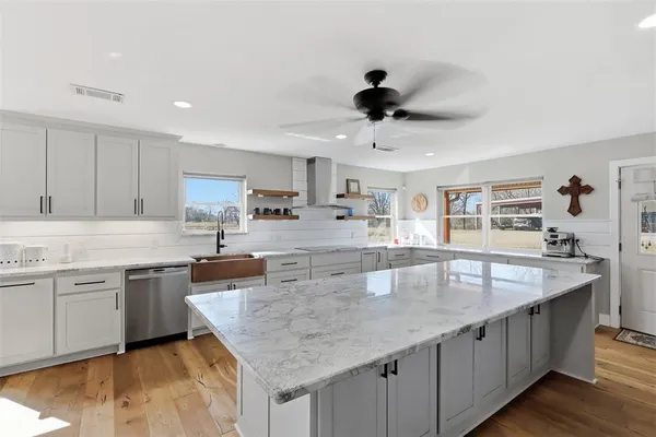 a large kitchen with stainless steel appliances granite countertop a sink counter space and cabinets