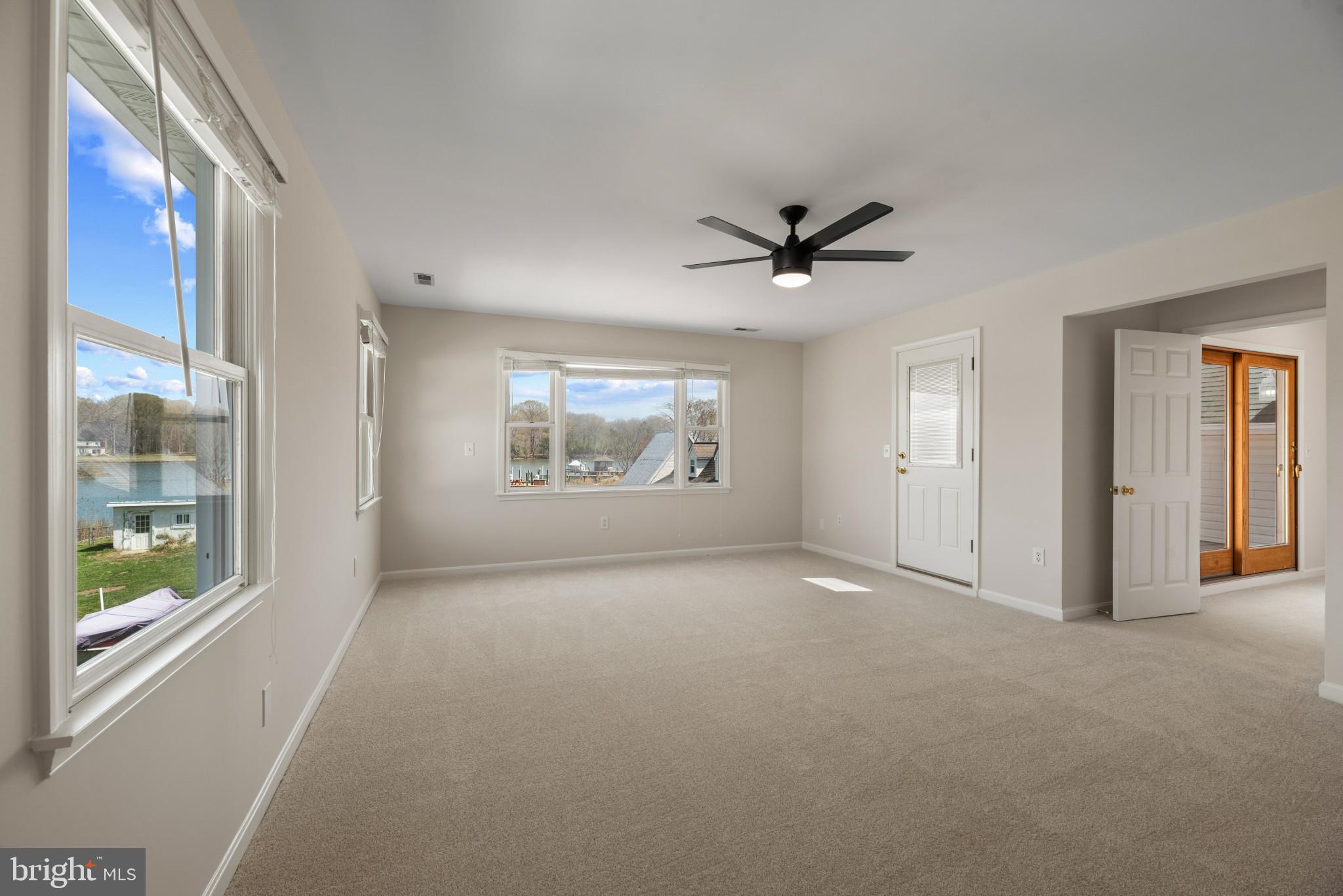 5929 Deale Beach Road Deale, MD 20751 - Photo 32 of 58 Empty room with light carpet, ceiling fan, and a w