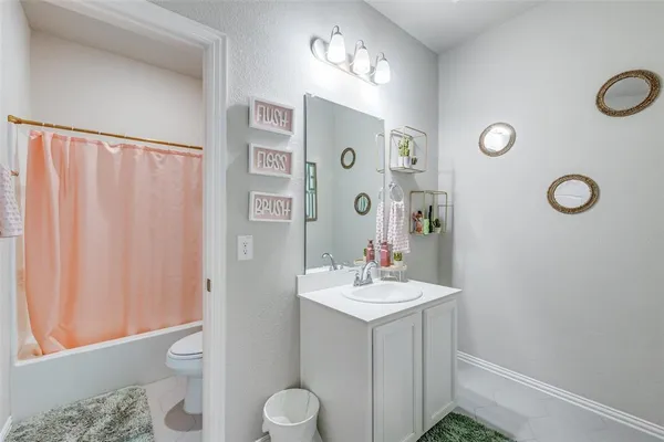 a bathroom with a sink mirror vanity and toilet