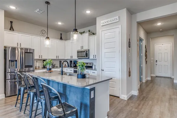 a kitchen with stainless steel appliances kitchen island granite countertop a refrigerator a sink and a stove