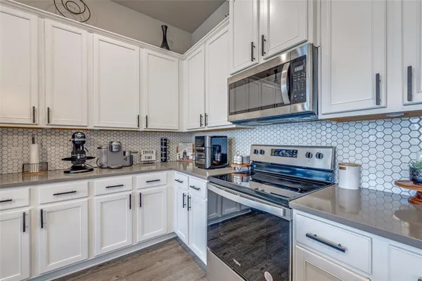 a kitchen with cabinets stainless steel appliances and a sink