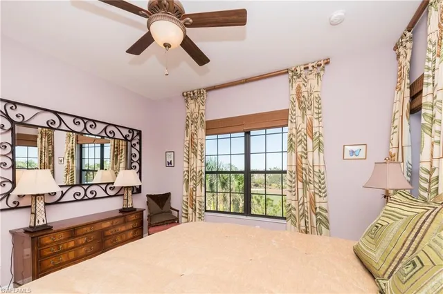a spacious bedroom with a large bed and a chandelier