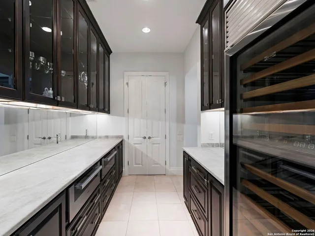 a view of a hallway with windows and chandelier