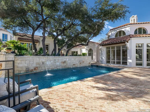 an aerial view of residential houses with outdoor space and trees