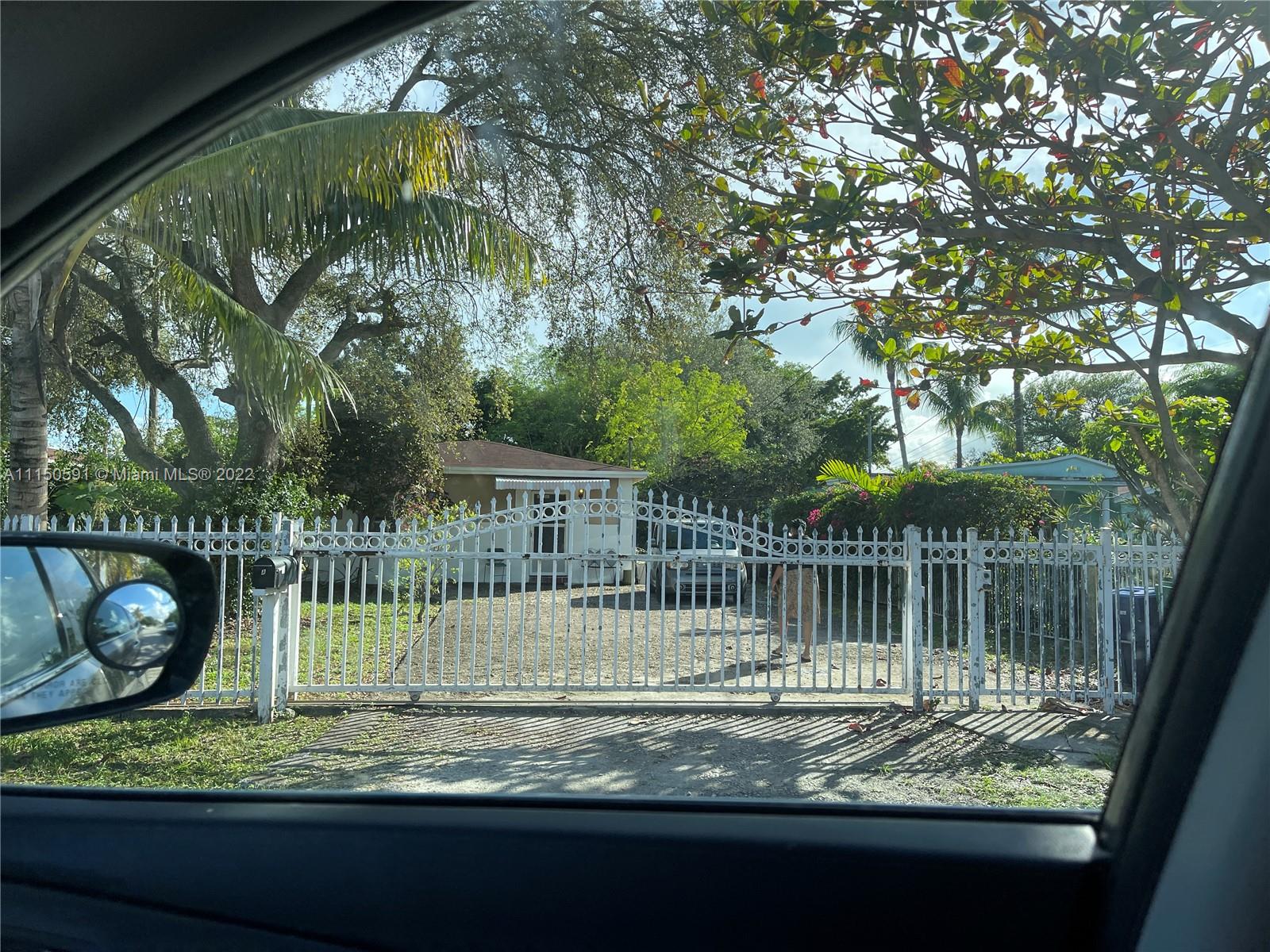 a view of a wooden fence with a small yard and plants