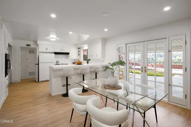 a kitchen with a sink a stove a refrigerator and white cabinets with wooden floor