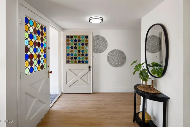 a living room with furniture a potted plant and a large window
