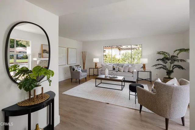 a living room with furniture a fireplace and a large window