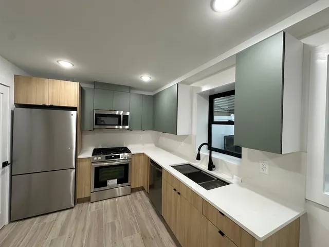 a kitchen with a sink stainless steel appliances and counter space