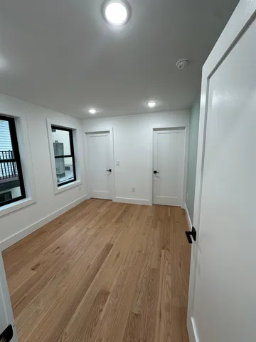 a view of a big room with wooden floor and windows