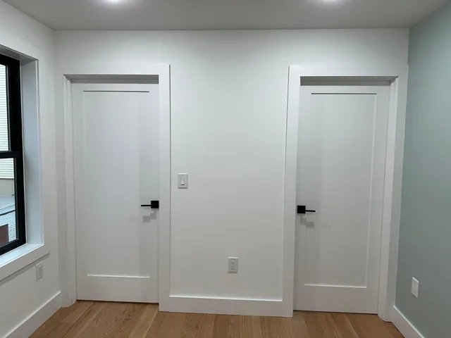 an empty room with wooden floor and entrance