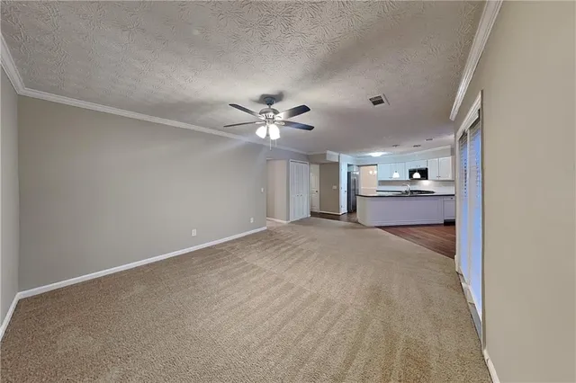 a view of a livingroom with a ceiling fan and entryway
