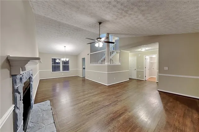 a view of empty room with wooden floor fireplace and windows