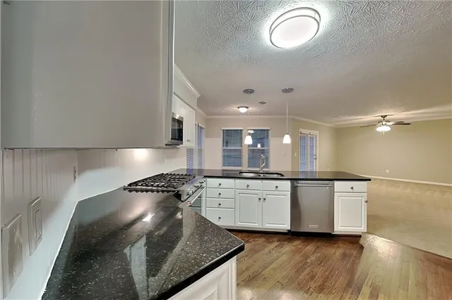 a kitchen with granite countertop a stove and a sink