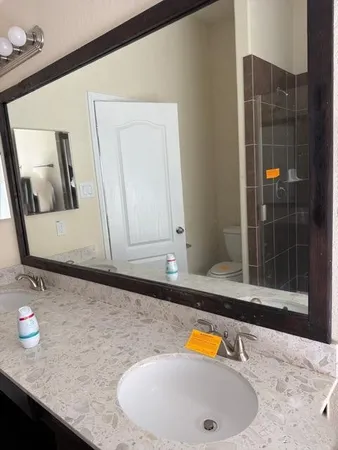 a bathroom with a granite countertop sink and a mirror