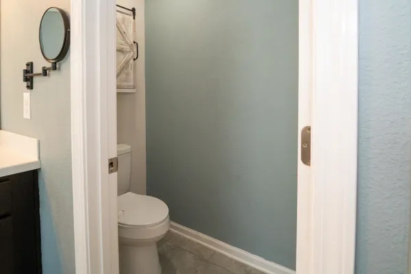 a bathroom with a granite countertop toilet and a sink