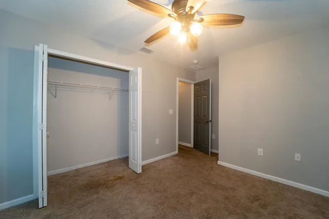 an empty room with a fan and a fan