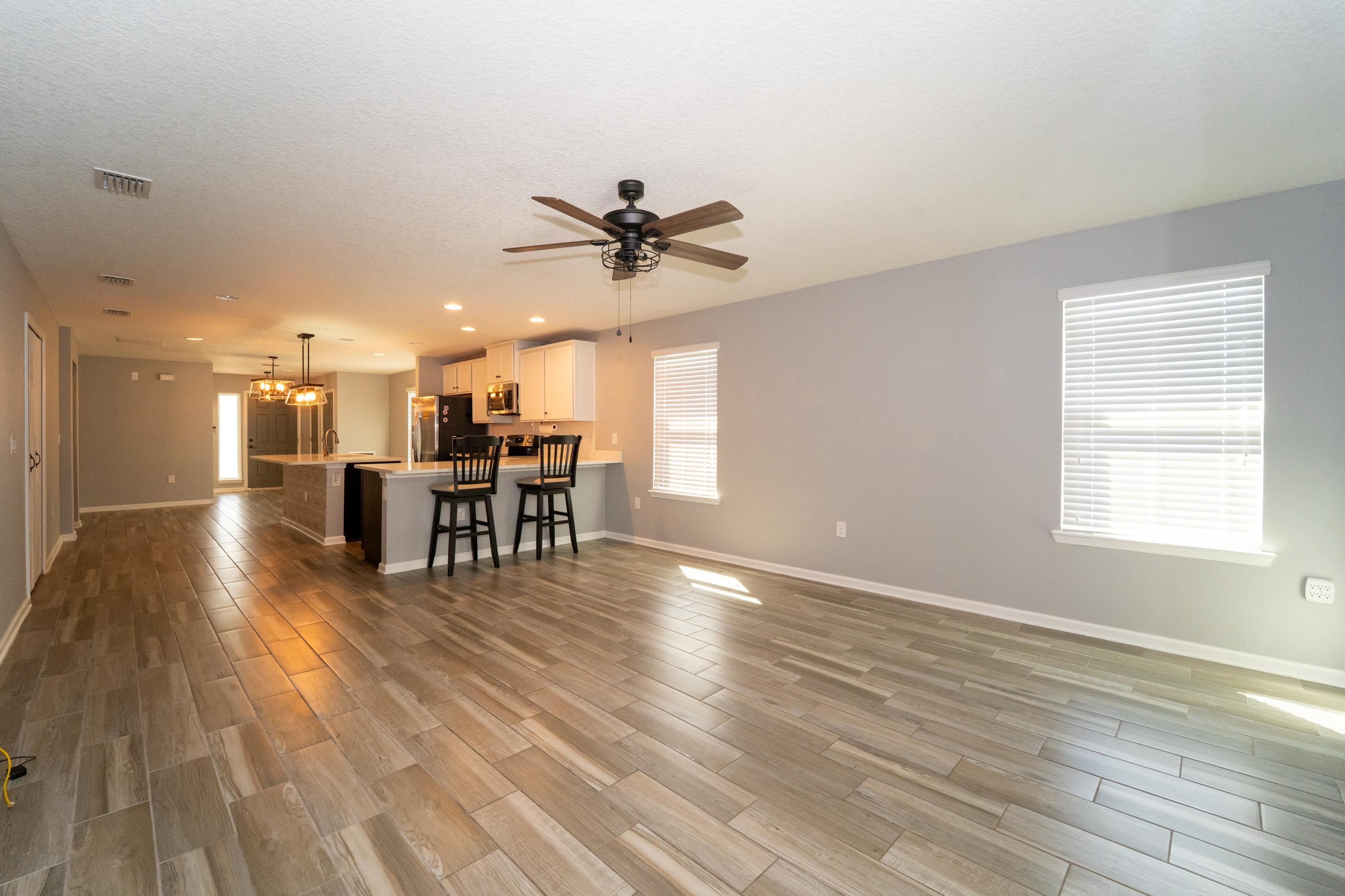 415 Santorini Court St. Augustine, FL 32086 - Photo 5 of 52 a view of a livingroom with furniture wooden floor a ceiling fan and windows