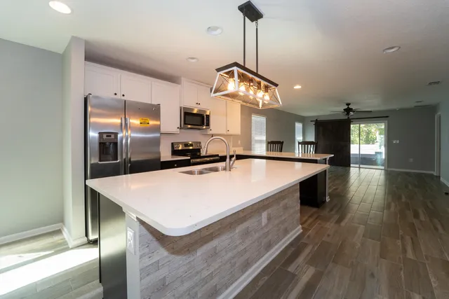 a large kitchen with kitchen island a wooden floor