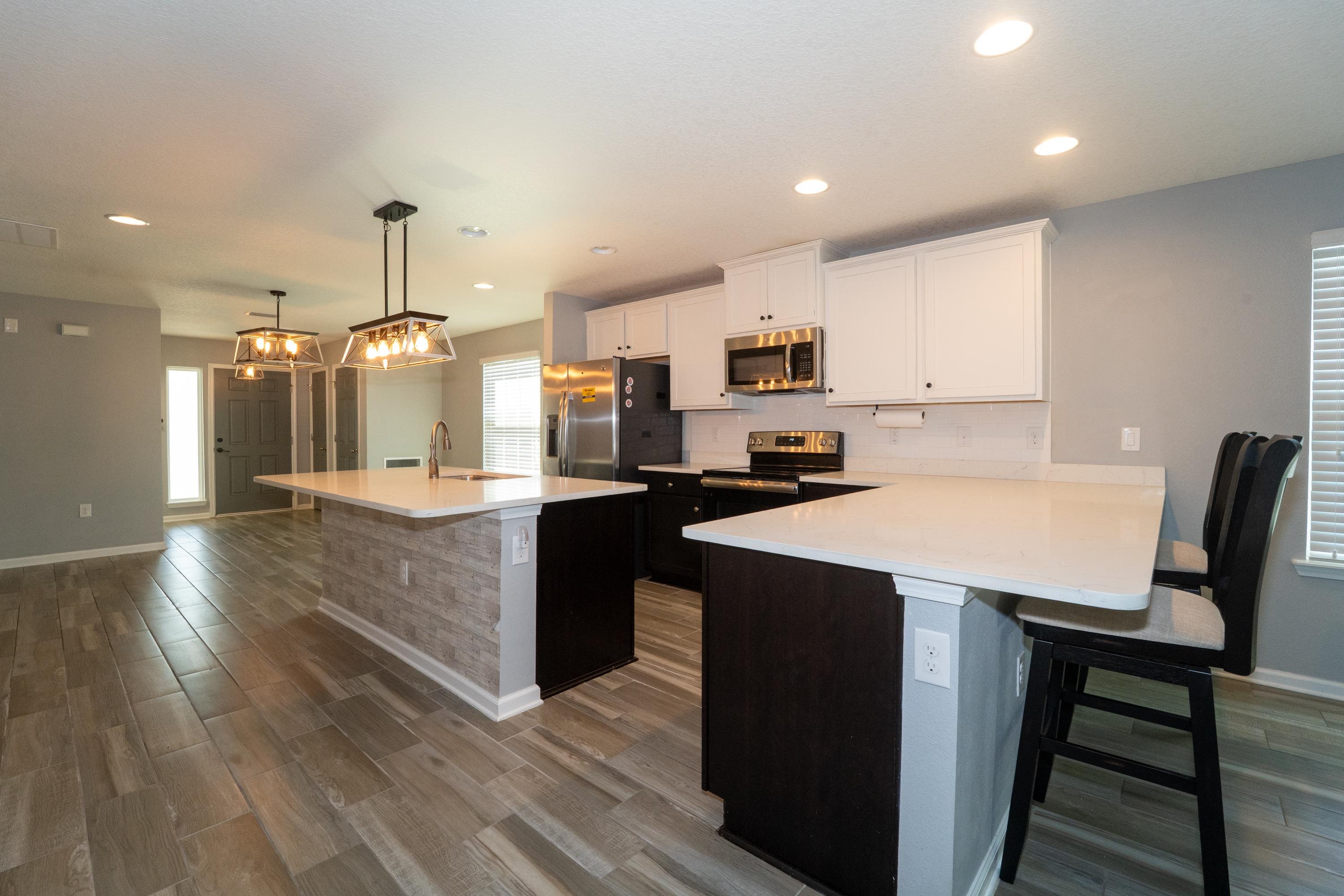 415 Santorini Court St. Augustine, FL 32086 - Photo 10 of 52 a large kitchen with kitchen island granite countertop a sink a stove a dining table and chairs