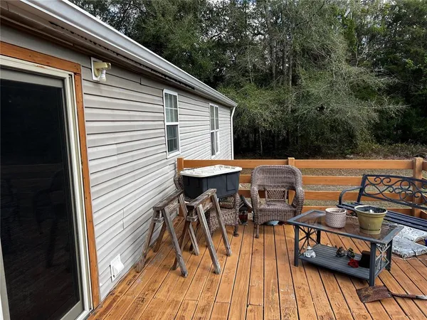 a view of a roof deck with table and chairs with wooden floor and fence