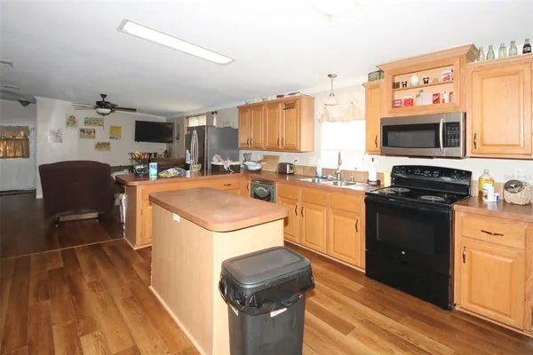 a kitchen with stainless steel appliances a refrigerator sink and wooden floor