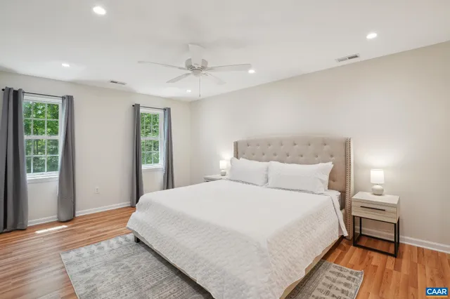 a bedroom with a large bed and a wooden floor