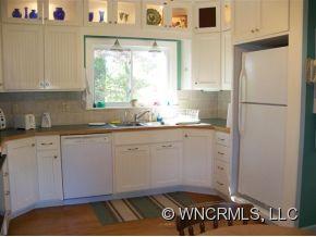 130 Bradshaw Road Tryon, NC 28782 - Photo 9 of 16 a kitchen with granite countertop white cabinets and white appliances