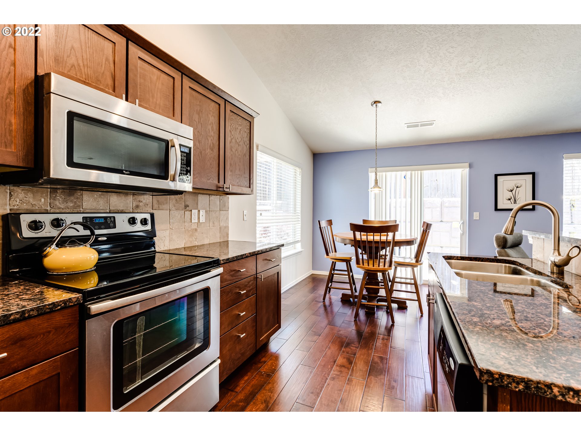 569 South 48th Street Springfield, OR 97478 - Photo 10 of 23 a kitchen with stainless steel appliances granite countertop a stove top oven a sink a dining table and chairs