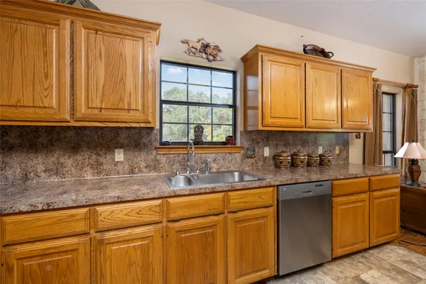 a kitchen with a refrigerator and wooden cabinets