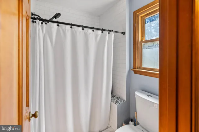 a bathroom with a shower curtain and a window