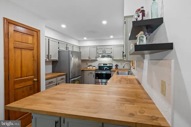 a kitchen with stainless steel appliances granite countertop a refrigerator and a stove top oven