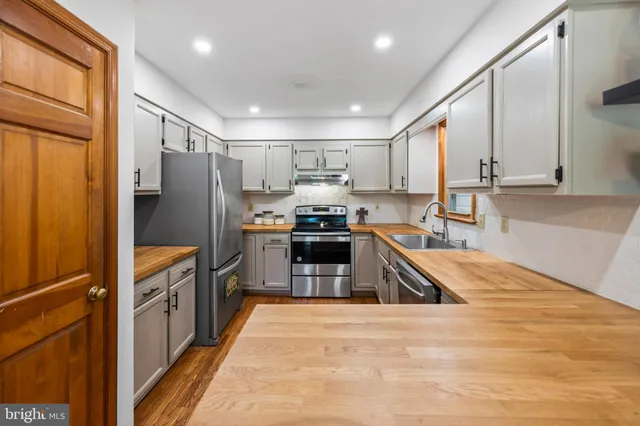a kitchen with granite countertop a refrigerator and a sink