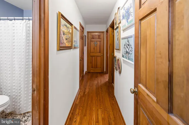 a view of a hallway with wooden floor and furniture