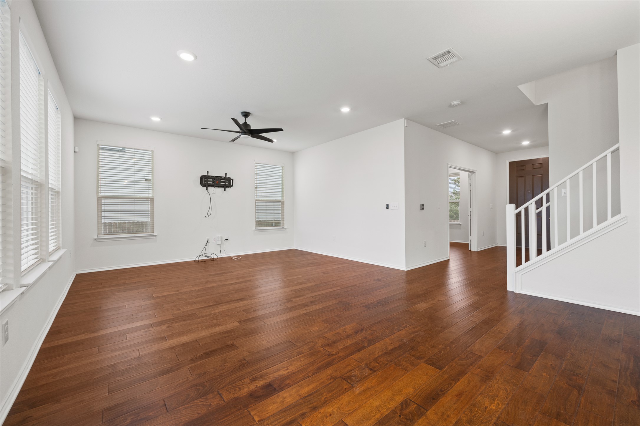 7009 Nutria Run Austin, TX 78744 - Photo 5 of 15 Rich hardwood flooring extends throughout this generous living area, featuring recessed lighting and a sleek ceiling fan.