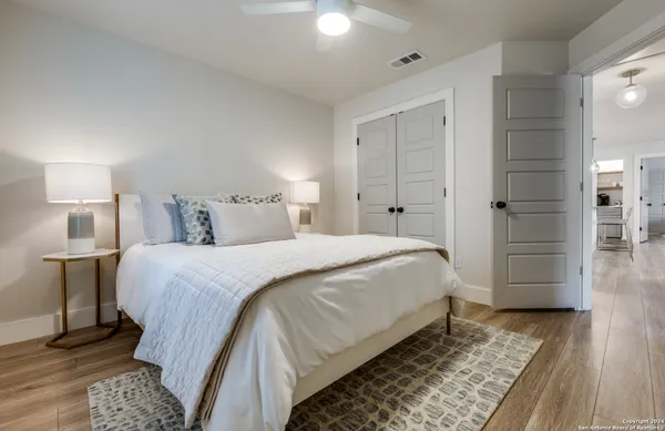 a bedroom with a bed and wooden floor