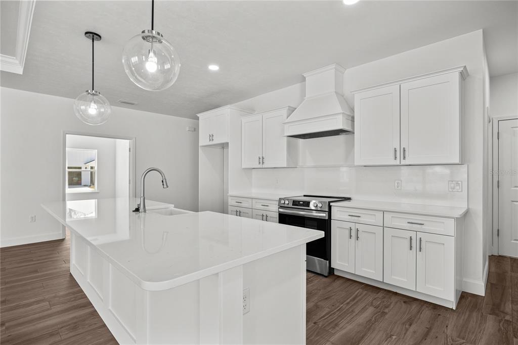 1132 Southwest 67th Drive Gainesville, FL 32607 - Photo 11 of 30 a kitchen with stainless steel appliances a white stove top oven cabinets and wooden floor