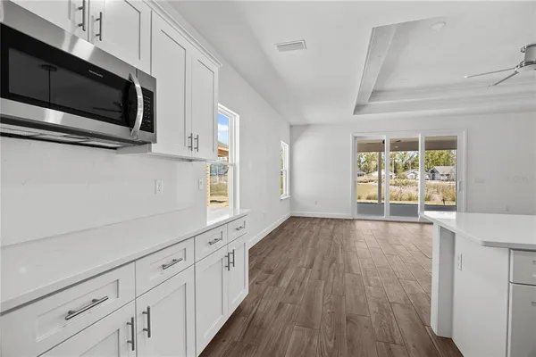 a view of a kitchen with wooden floor and electronic appliances