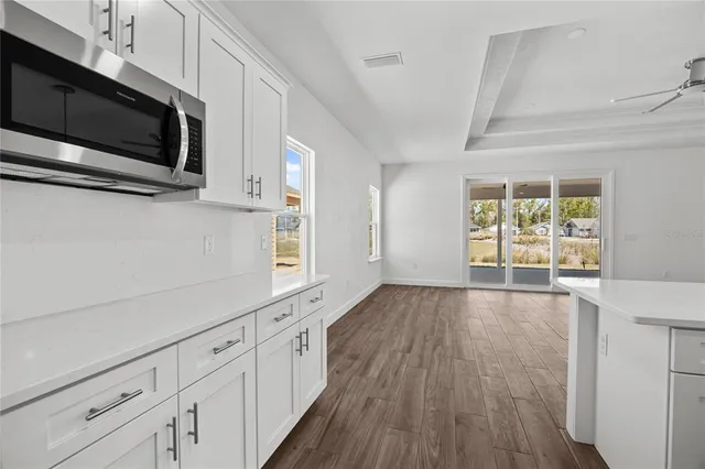 a view of a kitchen with wooden floor and electronic appliances