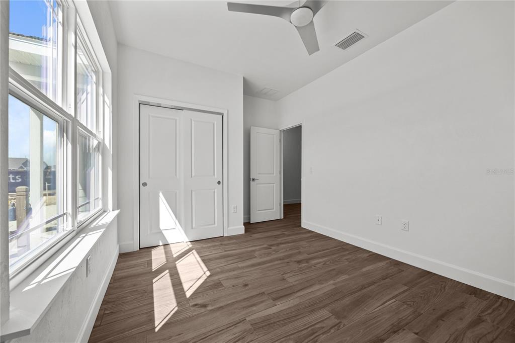1132 Southwest 67th Drive Gainesville, FL 32607 - Photo 22 of 30 a view of an empty room with wooden floor and a window