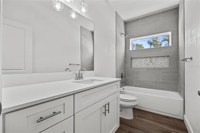 a bathroom with a granite countertop sink a toilet and a bathtub