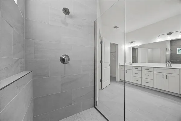 a bathroom with a granite countertop sink a mirror a shower and a bathtub