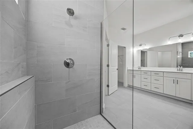 a bathroom with a granite countertop sink a mirror a shower and a bathtub