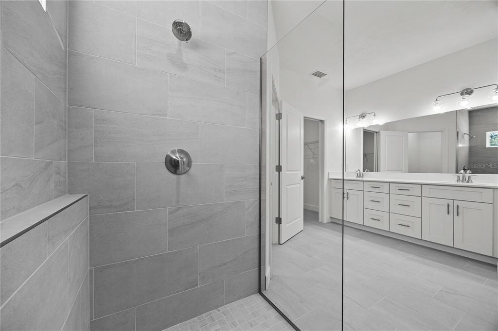1132 Southwest 67th Drive Gainesville, FL 32607 - Photo 8 of 30 a bathroom with a granite countertop sink a mirror a shower and a bathtub
