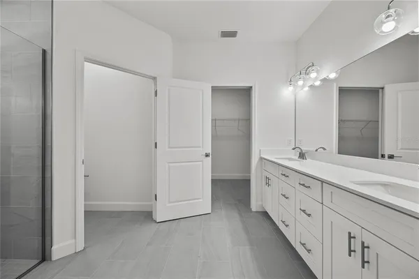 a bathroom with double vanity sink and a mirror