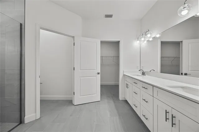 a bathroom with double vanity sink and a mirror