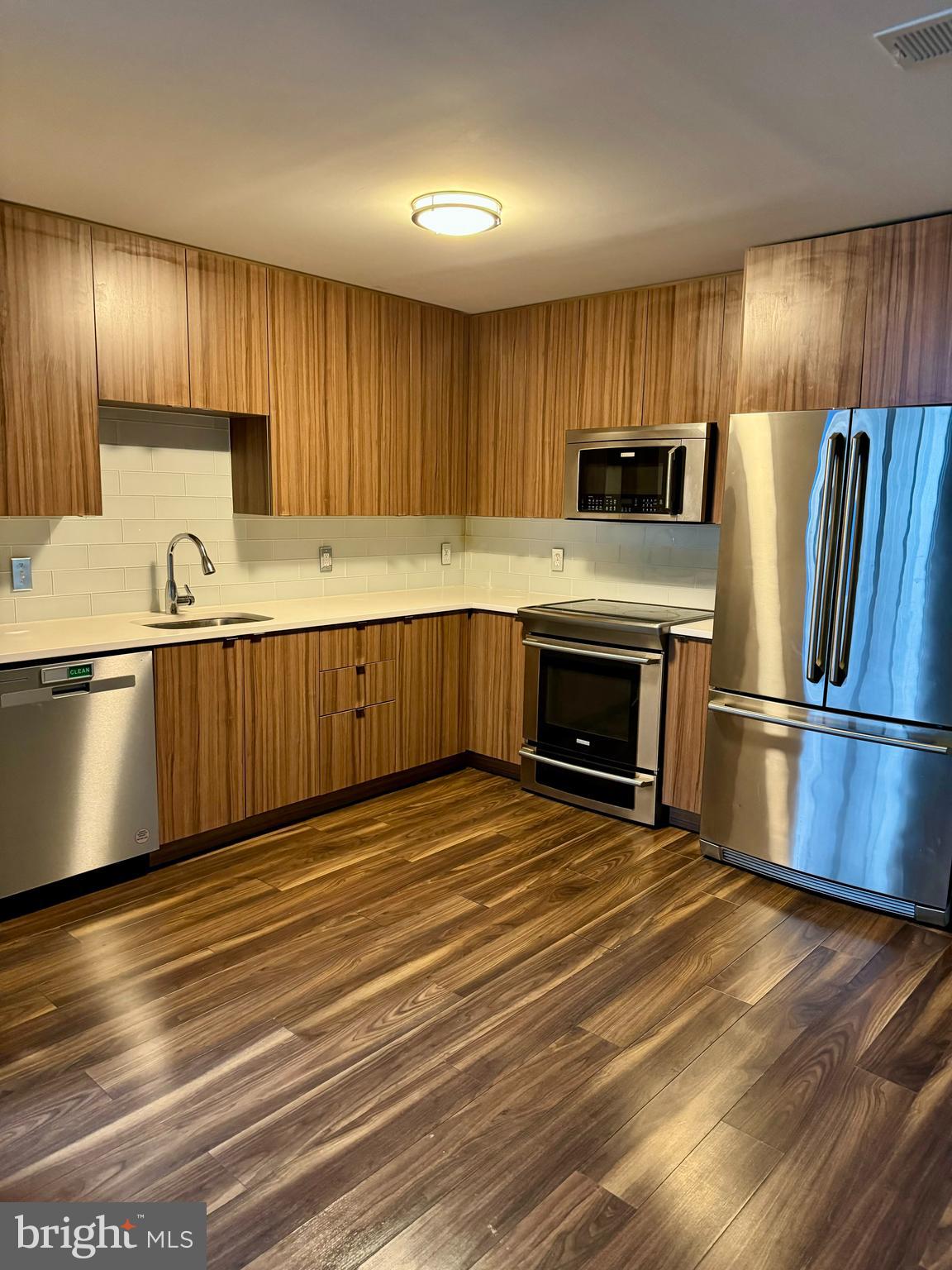 460 New York Avenue Northwest, Unit 407 Washington, DC 20001 - Photo 33 of 64 a kitchen with stainless steel appliances granite countertop a refrigerator a stove a sink and a microwave