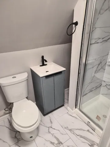 a bathroom with a sink a toilet and shower